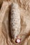 Close up on a whole traditional italian salami on a wooden cutting board