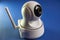 Close-up wi-fi camera with antenna for home video surveillance. Ip cctv camera on blue background. Selective focus,