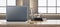 Close up of wide wooden designer office desk with empty computer, supplies and other objects. Blurry brick wall and window with