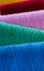 Close-up of winding spools with colorful vibrant thread lying on a table. Vertical view