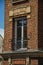 Close-up of window in a brick building and blue sky, early in the morning at Paris.