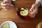 Close up of woman adding honey to tea with lemon