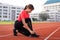 Close up of a woman athelete runner ties shoelace before jogging workout in the city stadium