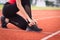 Close up of a woman athelete runner ties shoelace before jogging workout in the city stadium