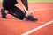 Close up of a woman athelete runner ties shoelace before jogging workout in the city stadium