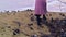 Close-up of woman in autumn boots walking on sand. Stock footage. Beautiful young woman walks along beach sand on cloudy