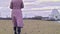 Close-up of woman in autumn boots walking on sand. Stock footage. Beautiful young woman walks along beach sand on cloudy