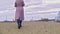 Close-up of woman in autumn boots walking on sand. Stock footage. Beautiful young woman walks along beach sand on cloudy