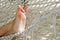 Close up on woman bare foot in white hammock