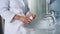 Close-up woman in bathrobe, stands at washbasin, takes her daily dose of vitamins, minerals and nutritional supplements