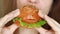 Close up woman biting vegan burger. Female mouth eating a hamburger