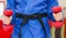 Close Up of Woman in Blue Judo Gi, and Black Belt, which is Trai