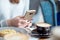 Close-up of woman in cafe holding mobile phone in hand.