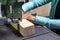 Close-up of a woman carpenter cutting a block of wood with a band saw