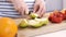 Close up on a woman carving some fruits