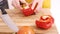 Close up on a woman carving sweet pepper