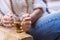 Close up of woman with coloured fashion accessories and jeans taking holding a glass of healthy tea for afternoon break time -