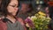 Close up of woman composing a bunch of flowers. selling floral arrangement. professional florist