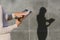 Close-up of a woman disinfects a pill with a napkin. Against the background of a gray concrete wall, a silhouette remains with a