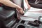 Close-up, woman driving car fastens her seat belt, automatic transmission, pink dress, in summer in city parking lot