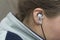 Close-up of woman ear with white earbud listenin to music