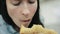 Close-up woman eating at food court unhealthy fried and fatty food in shopping mall. Young hungry woman chewing tasty