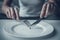 Close up. Woman Eating One Pea with Fork and Knife