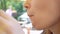 Close up. woman eats hamburger and drinks soda in cafe on street.