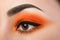 Close-up of woman eye with beautiful orange smokey eyes