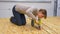 CLOSE UP: Woman fastens metal washers onto a plywood board with a power drill.