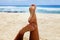 Close up of a woman feet relaxing on beach with the sea