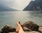 Close up of woman feet relaxing by a beautiful big lake lying on the edge of rocks