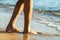 Close up of woman feet walking barefoot on sand leaving footprints on golden beach. Vacation, travel and freedom concept. People