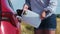 Close up woman filling up diesel exhaust fluid, DEF or petrol from the canister in the field.