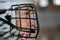 Close-up of woman floorball goalkeeper in helmet concetrating on game in gym.