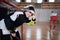 Close-up of woman floorball goalkeeper in helmet concetrating on game in gym.