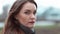 Close-up of a woman of forty years old with wind in her hair looks pensive