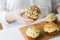 Close up of woman with glazed cupcakes or muffins