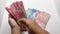 Close up of woman hand counting indonesian idr rupiah money sheet by sheet