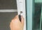 Close up woman hand hold house key with keyhole for front door entrance