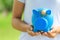 Close-up of woman hand holding blue piggy bank attached to the plaster on the head, Save money for Medical insurance and Health