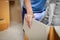 Close up on woman hand holding and carrying a cardboard box with stuffs moving to new house on moving day.