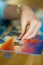 Close-up on woman hand playing puzzles at home. Connecting jigsaw puzzle pieces in a living room table, assembling a jigsaw puzzle