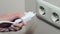 Close-up woman hand puts plug in the Electricity socket. Female hand unplugging