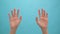 Close up of woman hand showing waving bye on the blue background