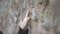 Close up on woman hand touching stone wall