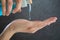 Close-up of woman hands applying and using blue hand sanitiser gel from a clear bottle protection from Coronavirus COVID-19