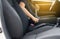 Close up of woman hands fastening or putting seat belt in car,Transportation and vehicle concept