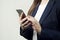 Close-up of woman hands hold phone, woman wears suit