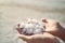 Close up woman hands holding crystallized salt natural mineral formation at Dead Sea coastline